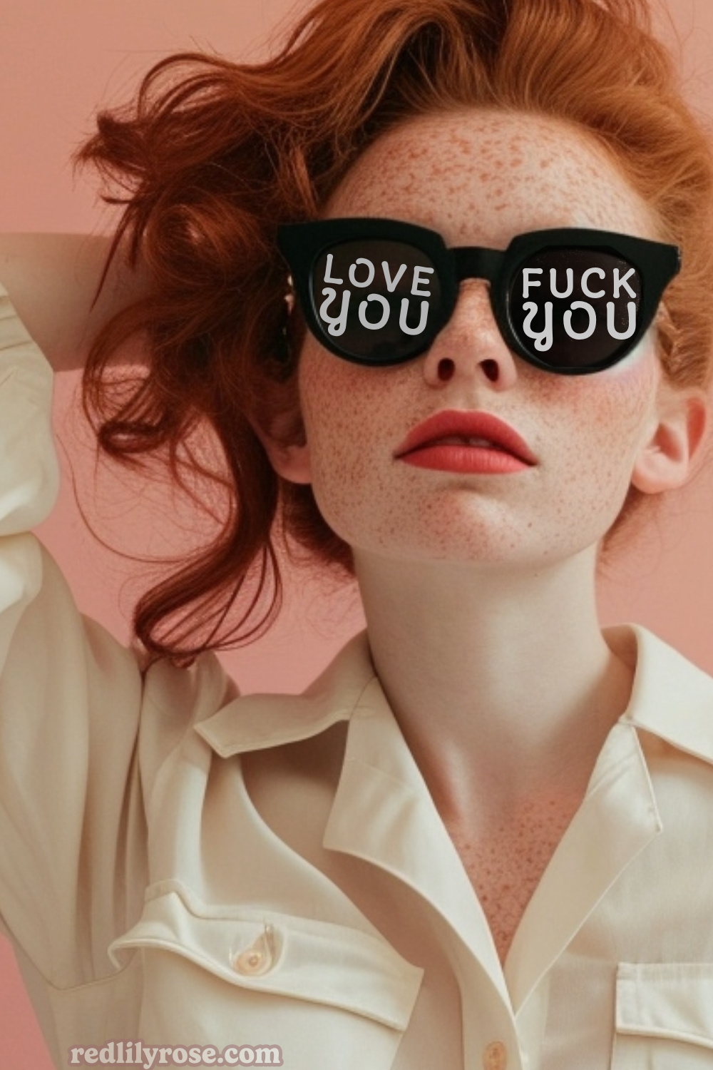 A freckled redhead model with a playful expression wears sunglasses with the phrases "LOVE YOU" and "FUCK YOU" on each lens, and a light beige blouse against a pink background. The website "redlilyrose.com" is at the bottom.